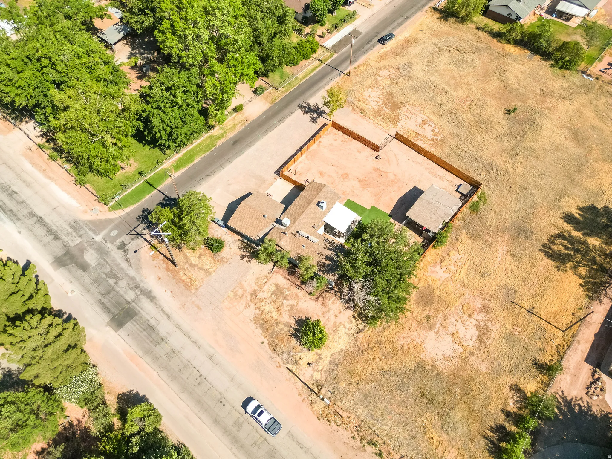 Corner lot property featuring a brown shingle roof, a covered patio structure, and a fenced backyard area