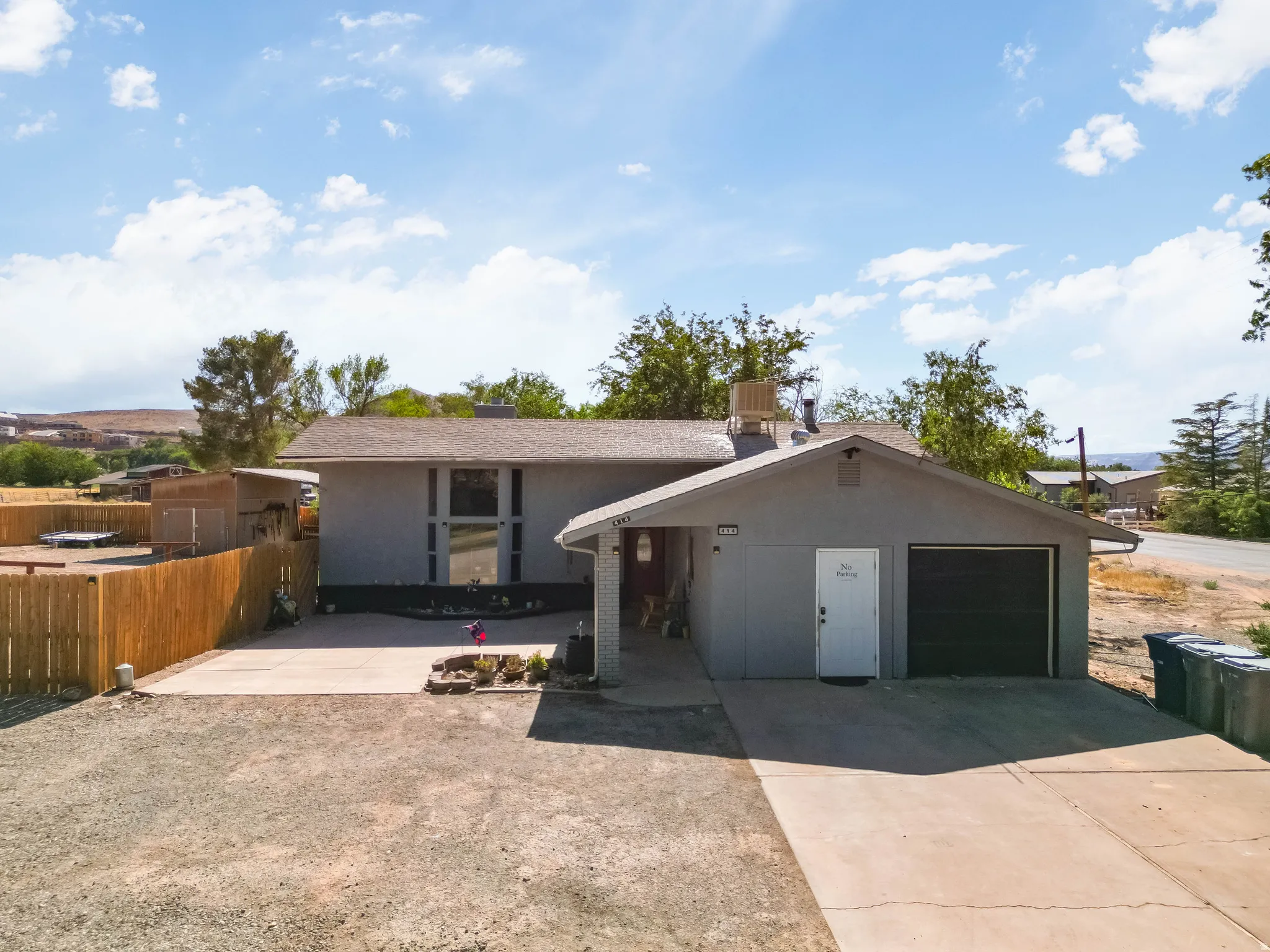 Single-story residence featuring a two-car garage, partial fencing, and a concrete driveway