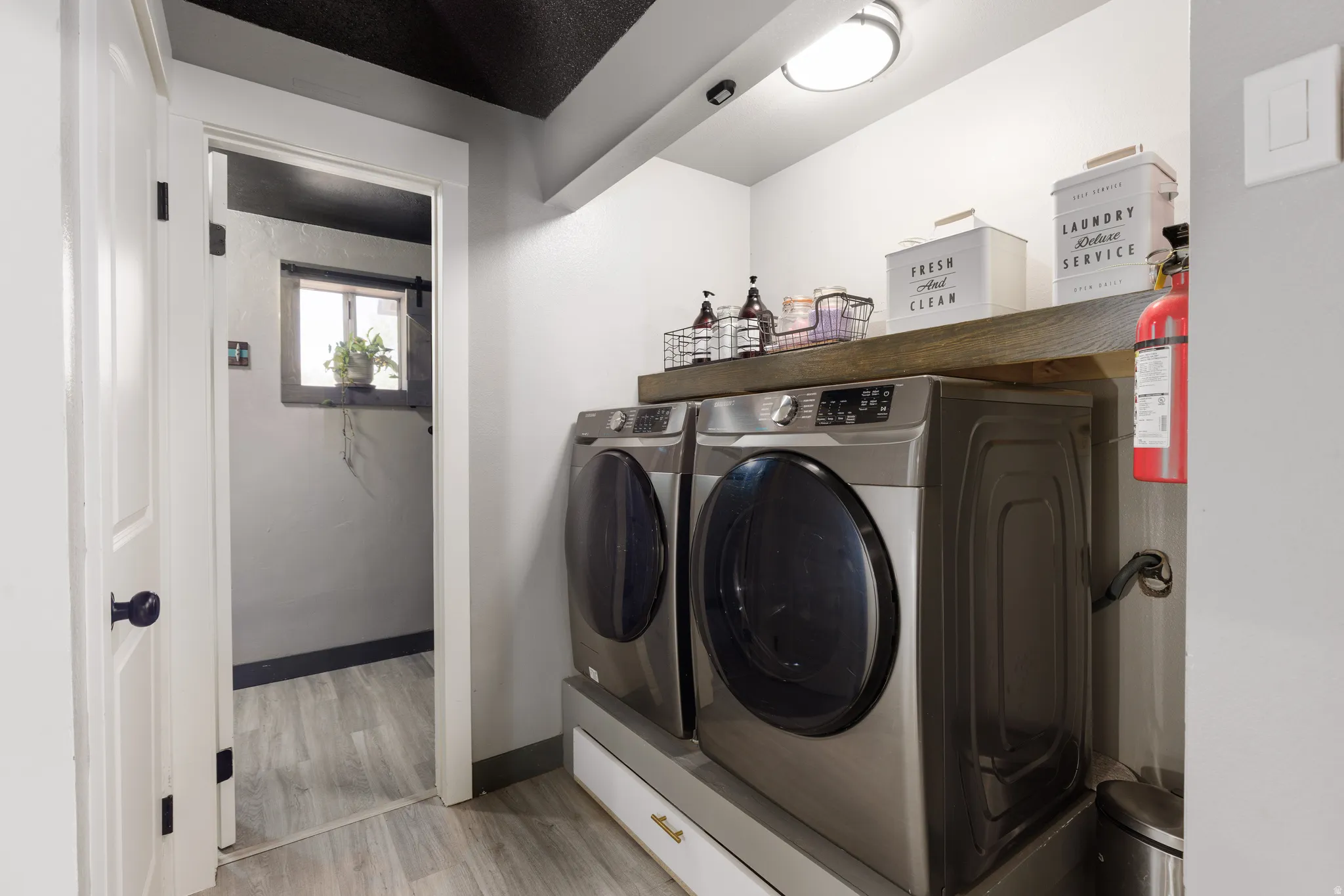 Dedicated laundry area featuring a wood-finish countertop, overhead lighting, and wood-finish flooring