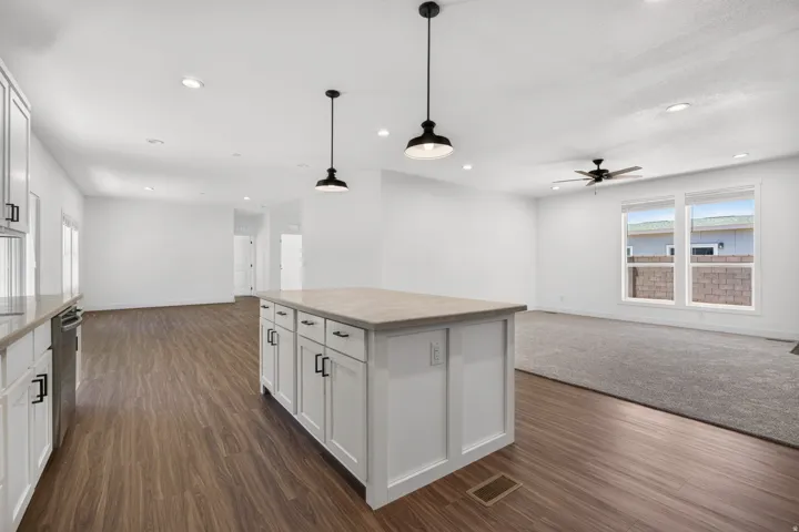 Kitchen featuring a central island with white cabinetry and a light-toned countertop