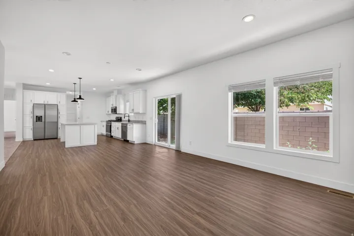 Open-concept living space featuring wood-finish flooring, recessed lighting, and a modern kitchen