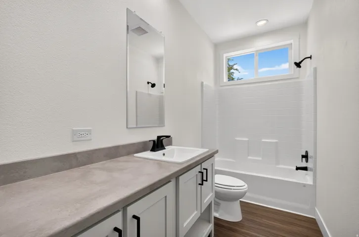 Bathroom featuring a white vanity with gray countertop, undermount sink, and matte black faucet