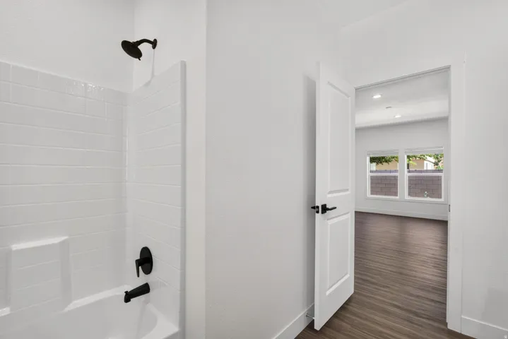 Full bathroom featuring a white subway tile tub surround, black finish shower fixtures, and a built-in tub niche
