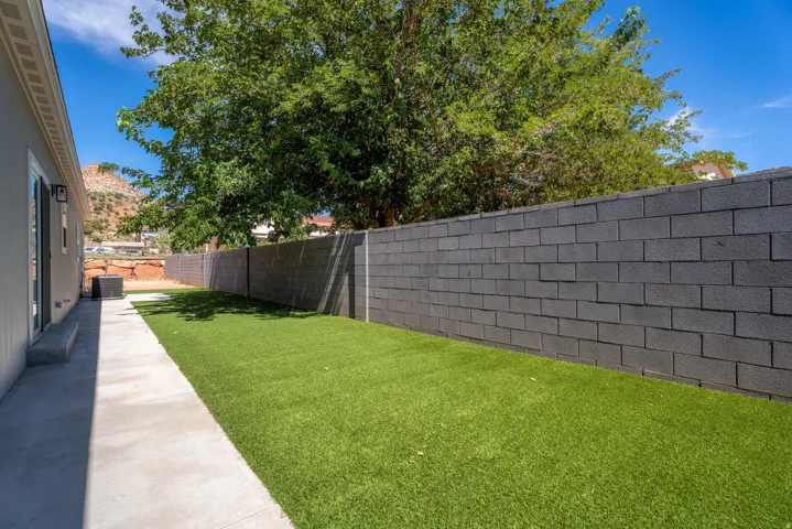 Expansive rear yard featuring a paved patio and artificial turf