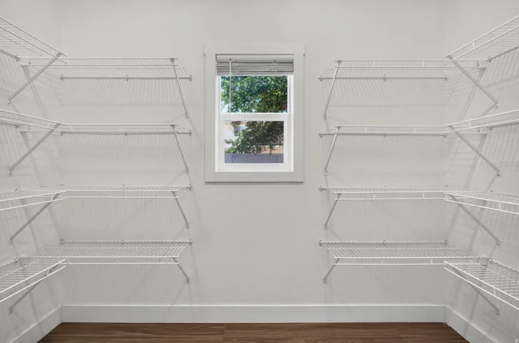 Customizable closet system featuring white wire shelving and wood-finish flooring