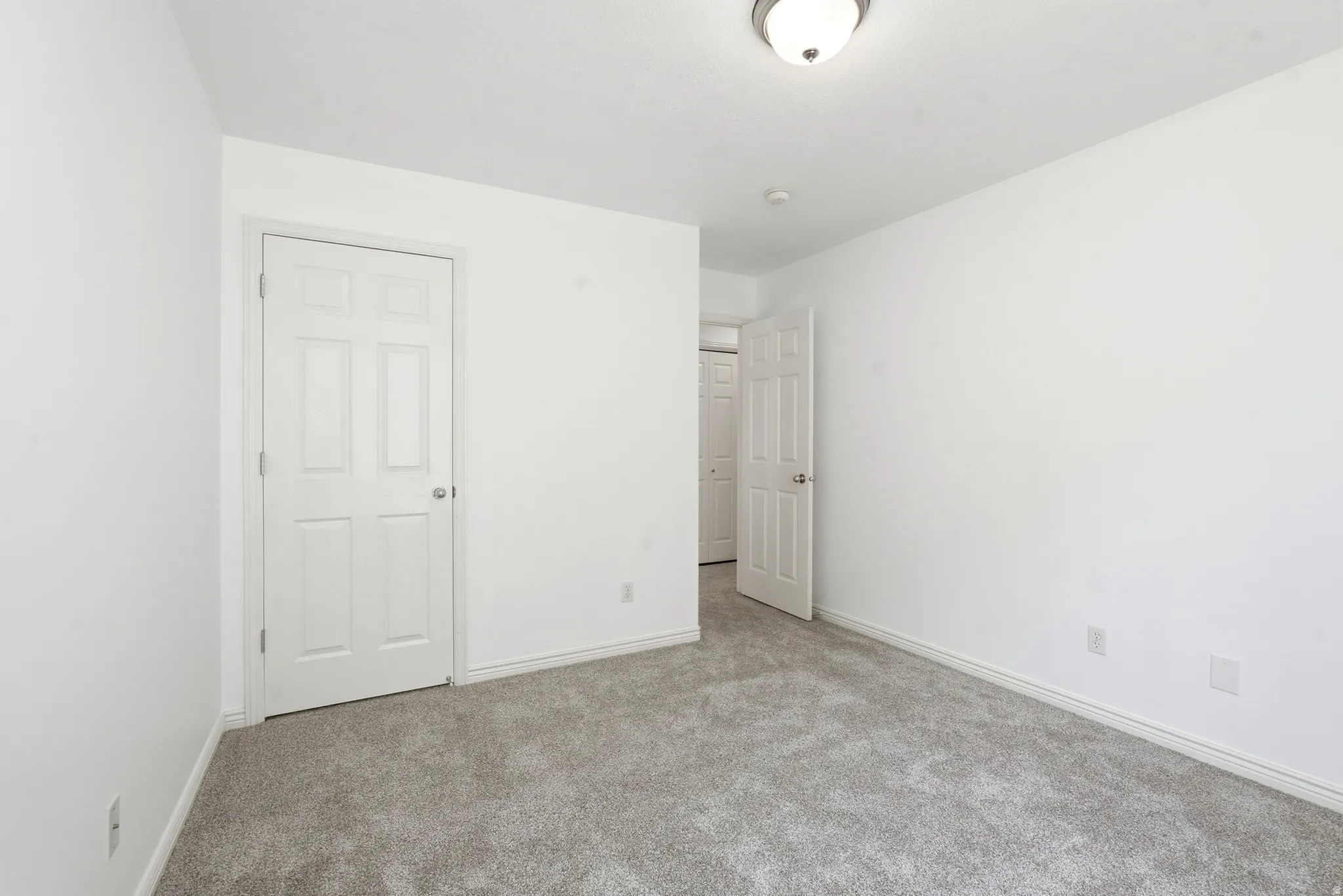 Interior room featuring light gray carpet, white walls, and white trim
