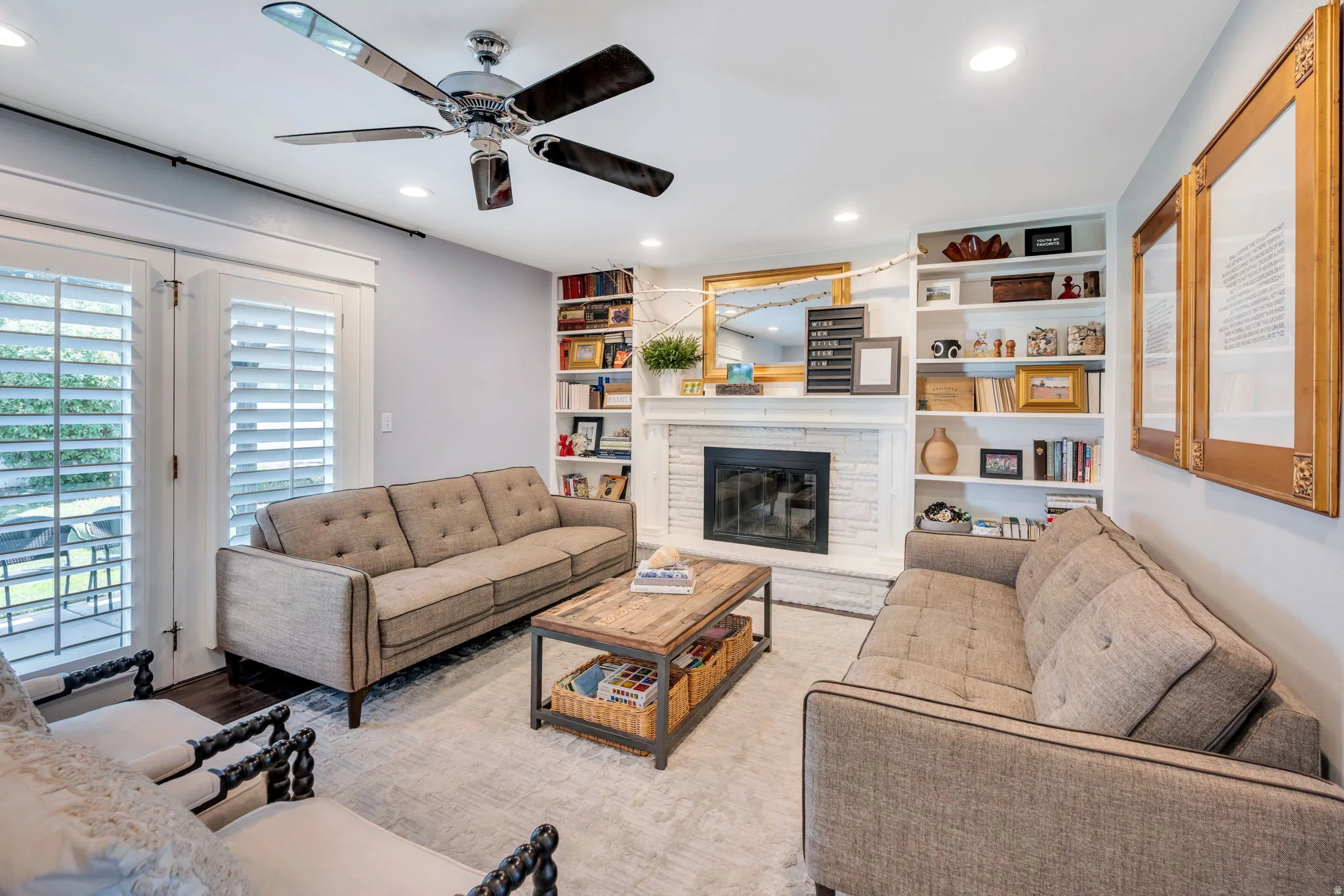 Living room featuring a white brick wood fireplace, built-in shelving, recessed lighting, and a ceiling fan