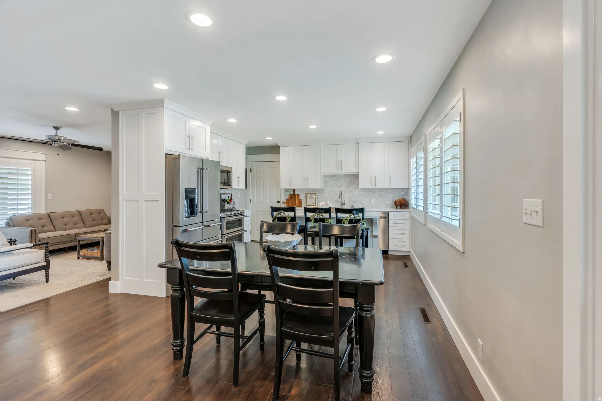 Kitchen with white shaker cabinetry, stainless steel appliances, and a tile backsplash