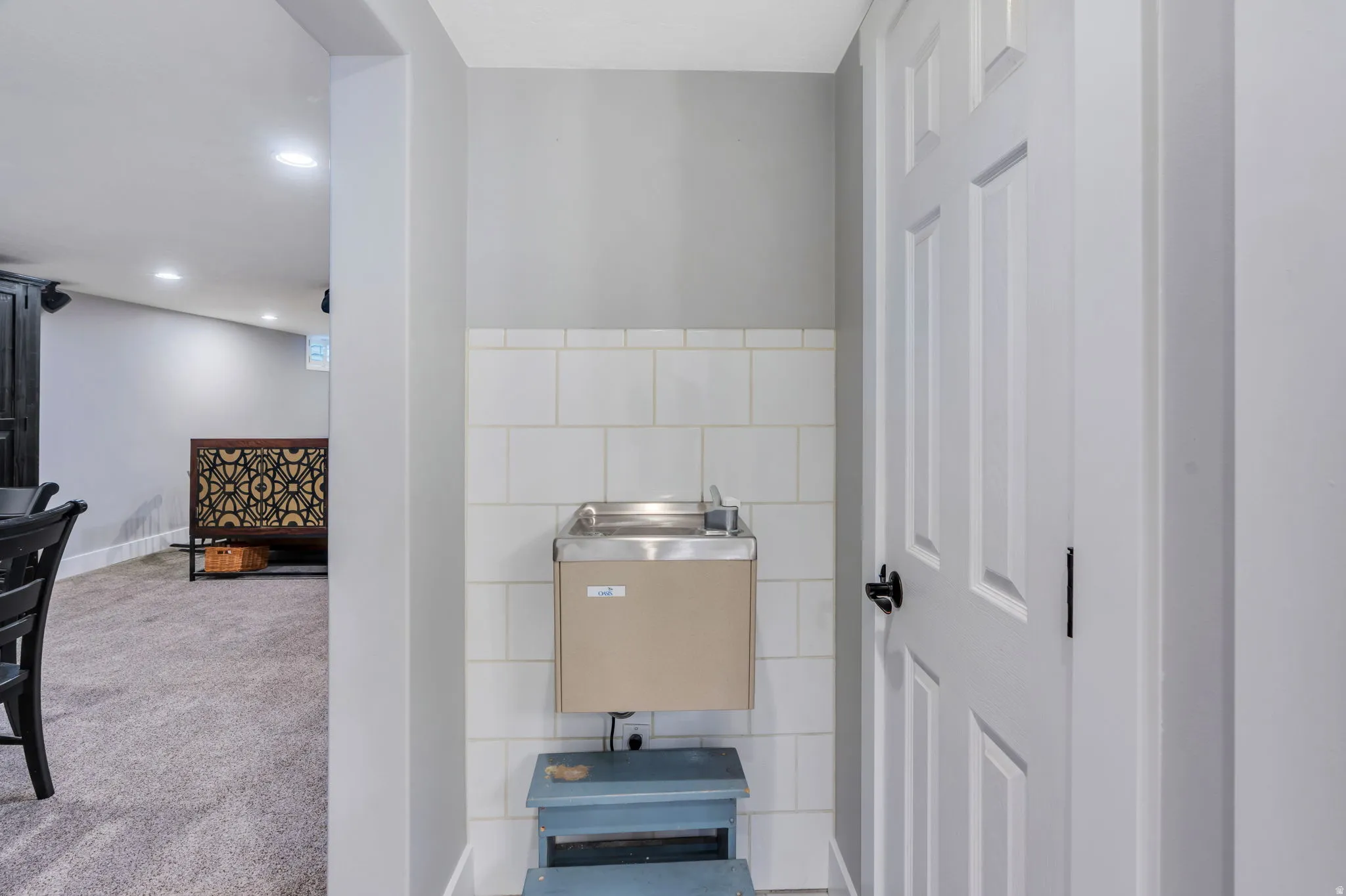 Built-in cooled water fountain with white tile backsplash.