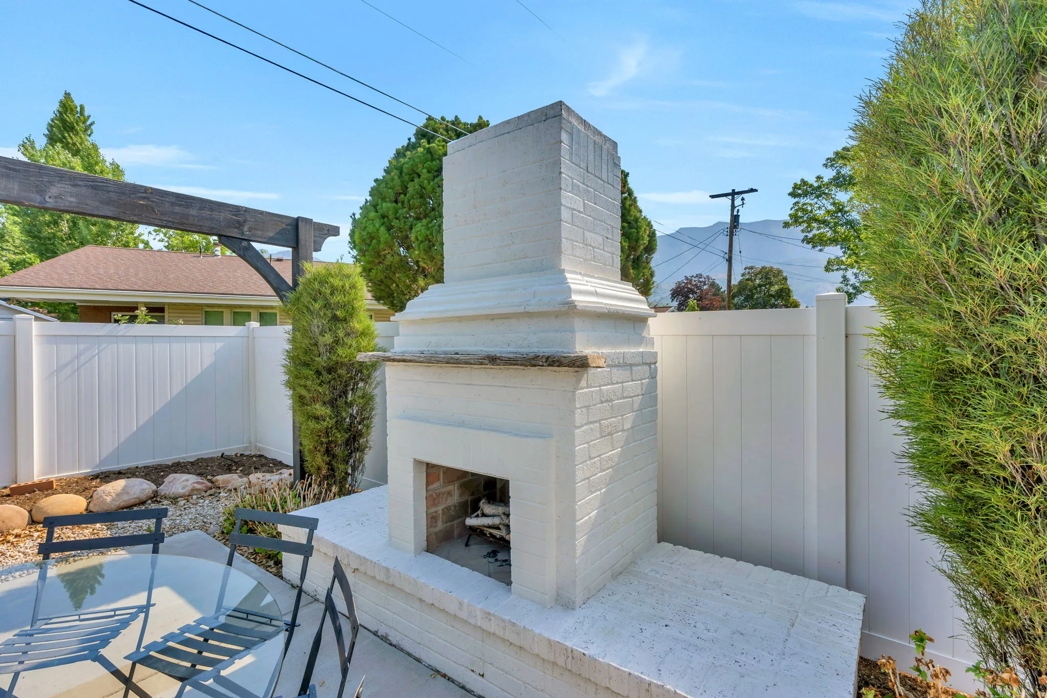 Outdoor brick fireplace with a white painted finish and integrated hearth