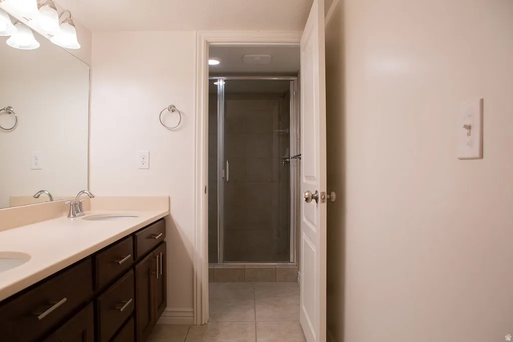 Double vanity with integrated sinks, dark wood cabinetry, and brushed nickel hardware