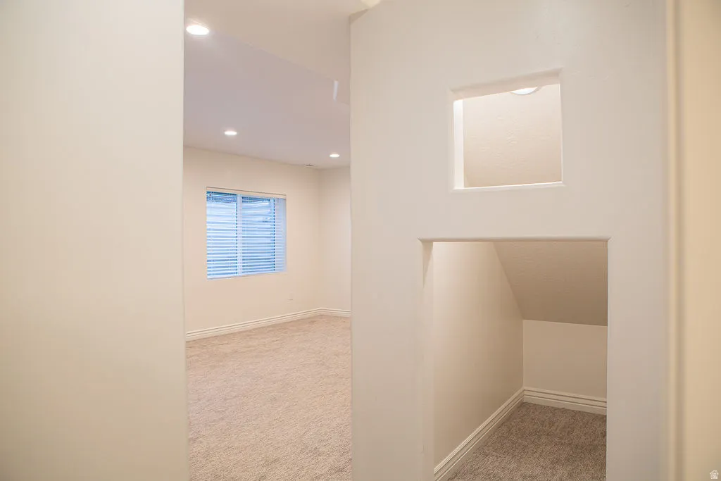 Carpeted interior space with a window featuring horizontal blinds, recessed lighting, and white baseboard molding