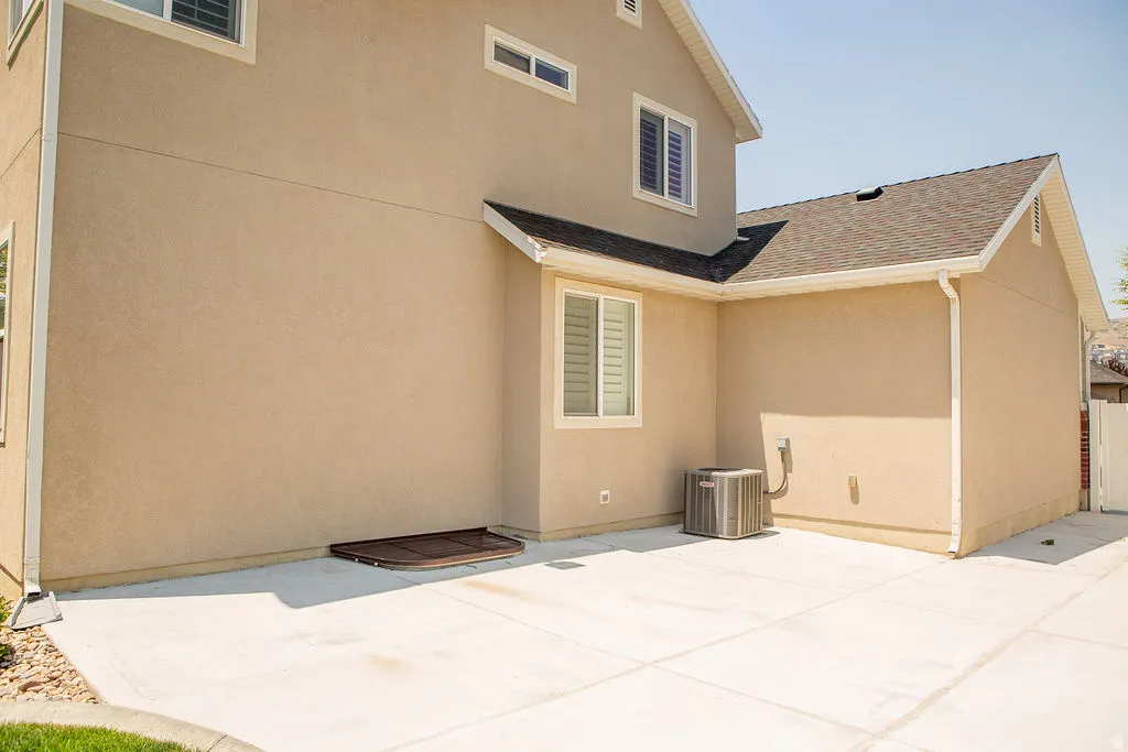 Rear elevation with stucco siding and a concrete patio