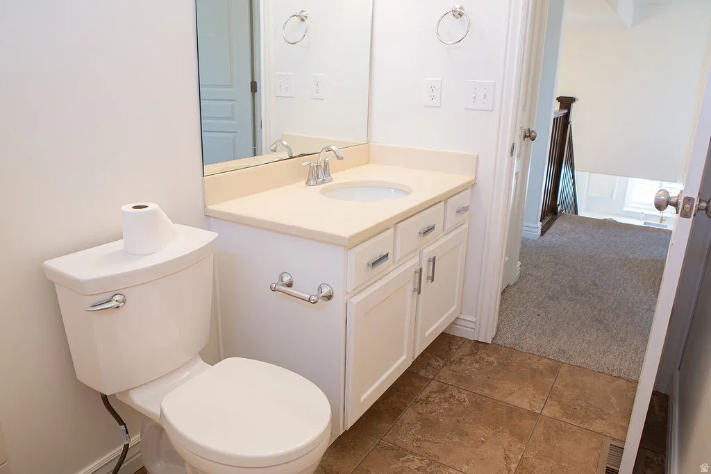 Bathroom featuring a white vanity with a light-toned countertop, an undermount sink with a chrome faucet, and a large wall-mounted mirror
