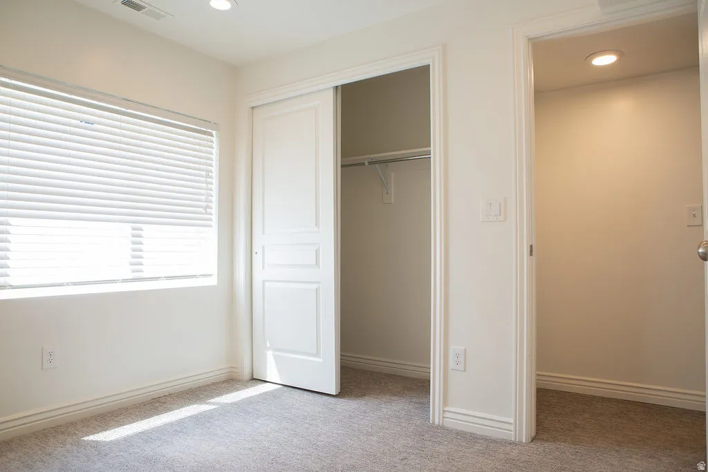 Bedroom featuring neutral-toned carpeting and white baseboards