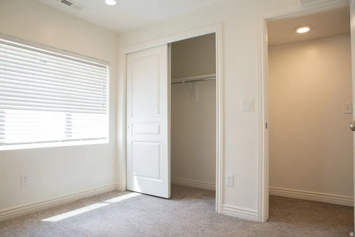 Bedroom featuring neutral-toned carpeting and white baseboards