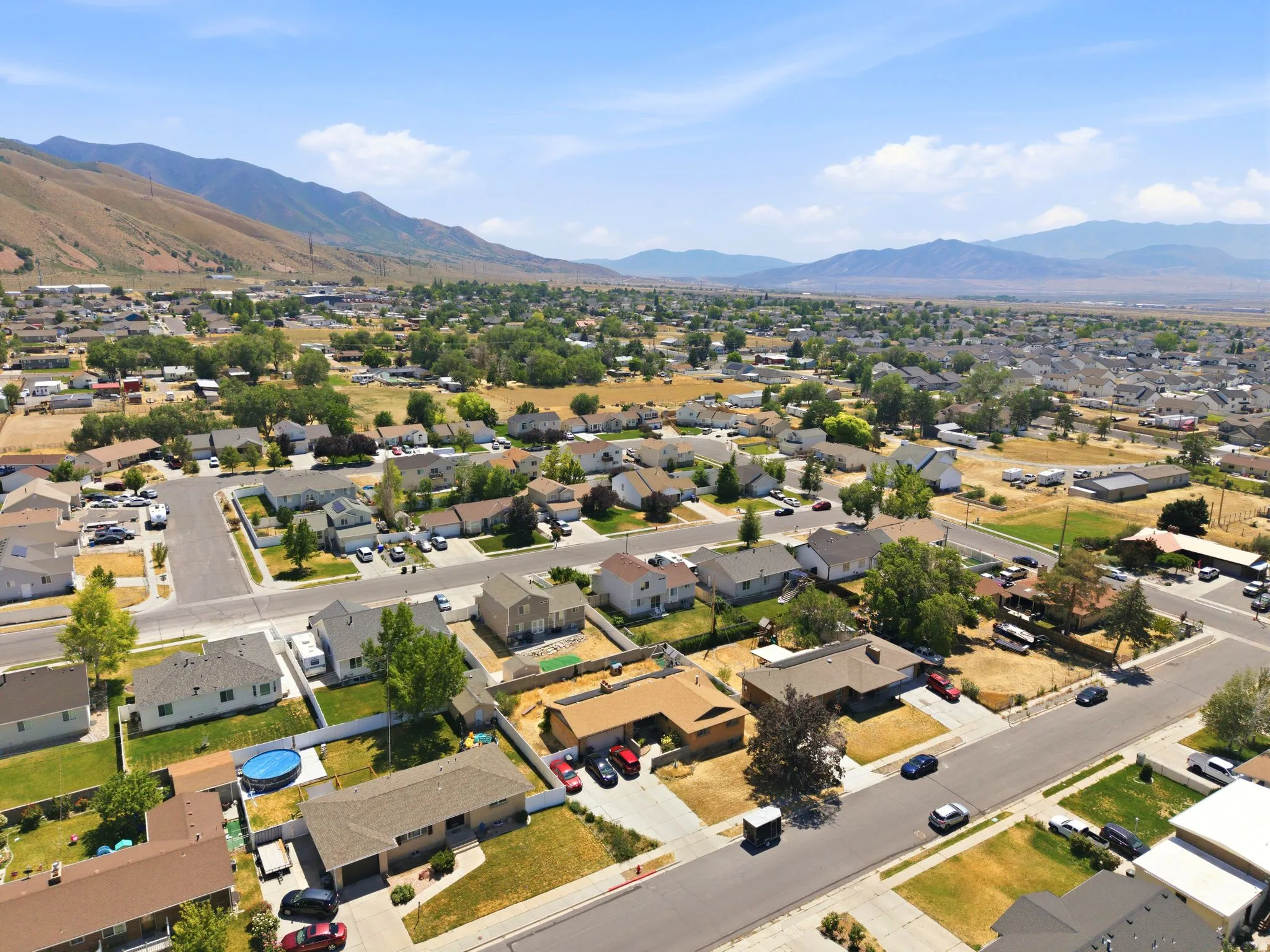 Residential neighborhood with mountain scenery, featuring single-story and two-story homes, established landscaping, and paved streets