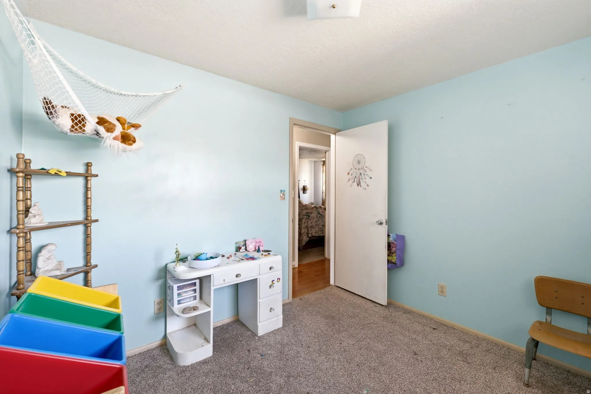 Room featuring light blue walls, gray carpet, and a white ceiling