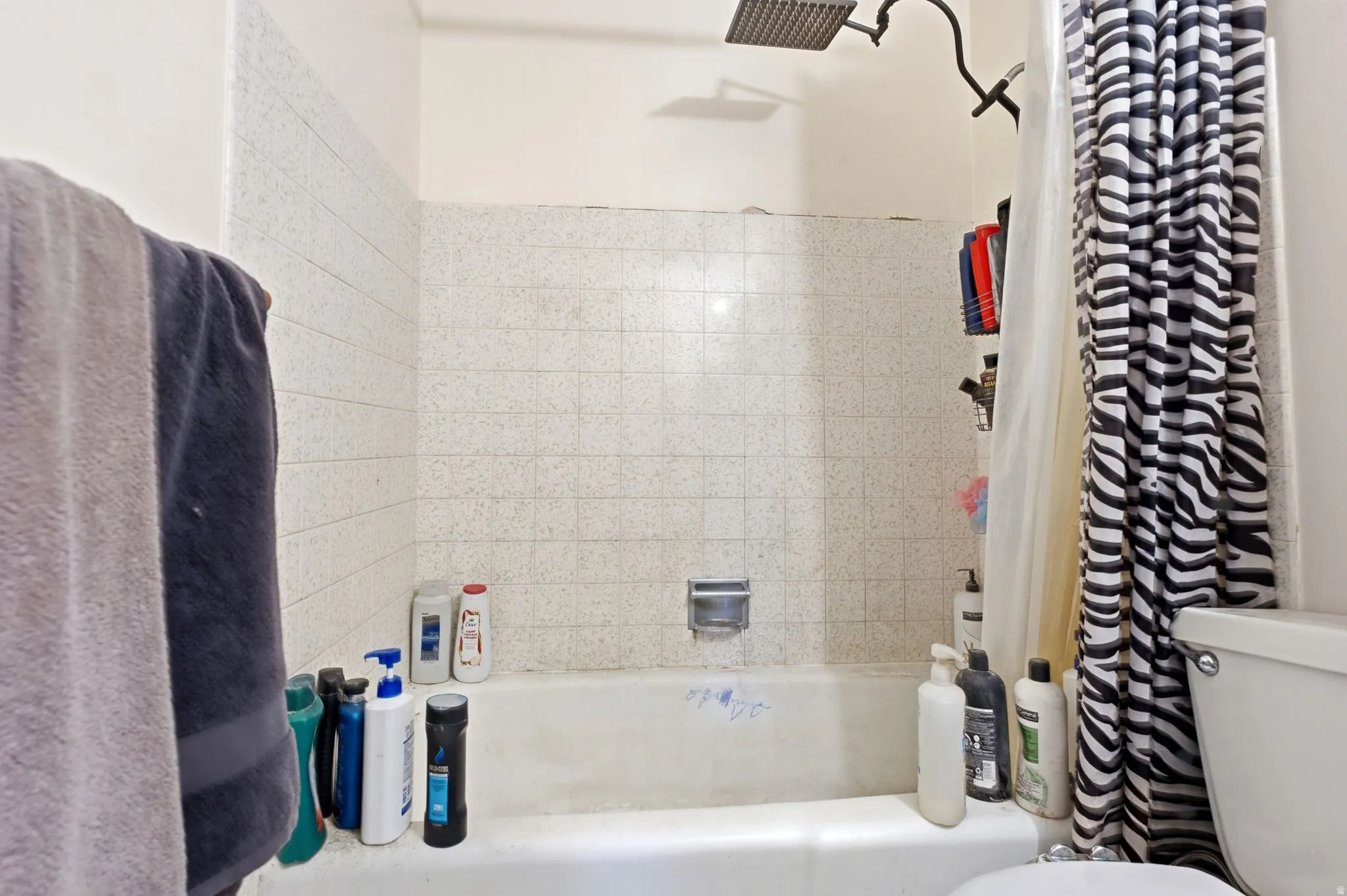 Bathtub with a tiled surround and a rainfall showerhead