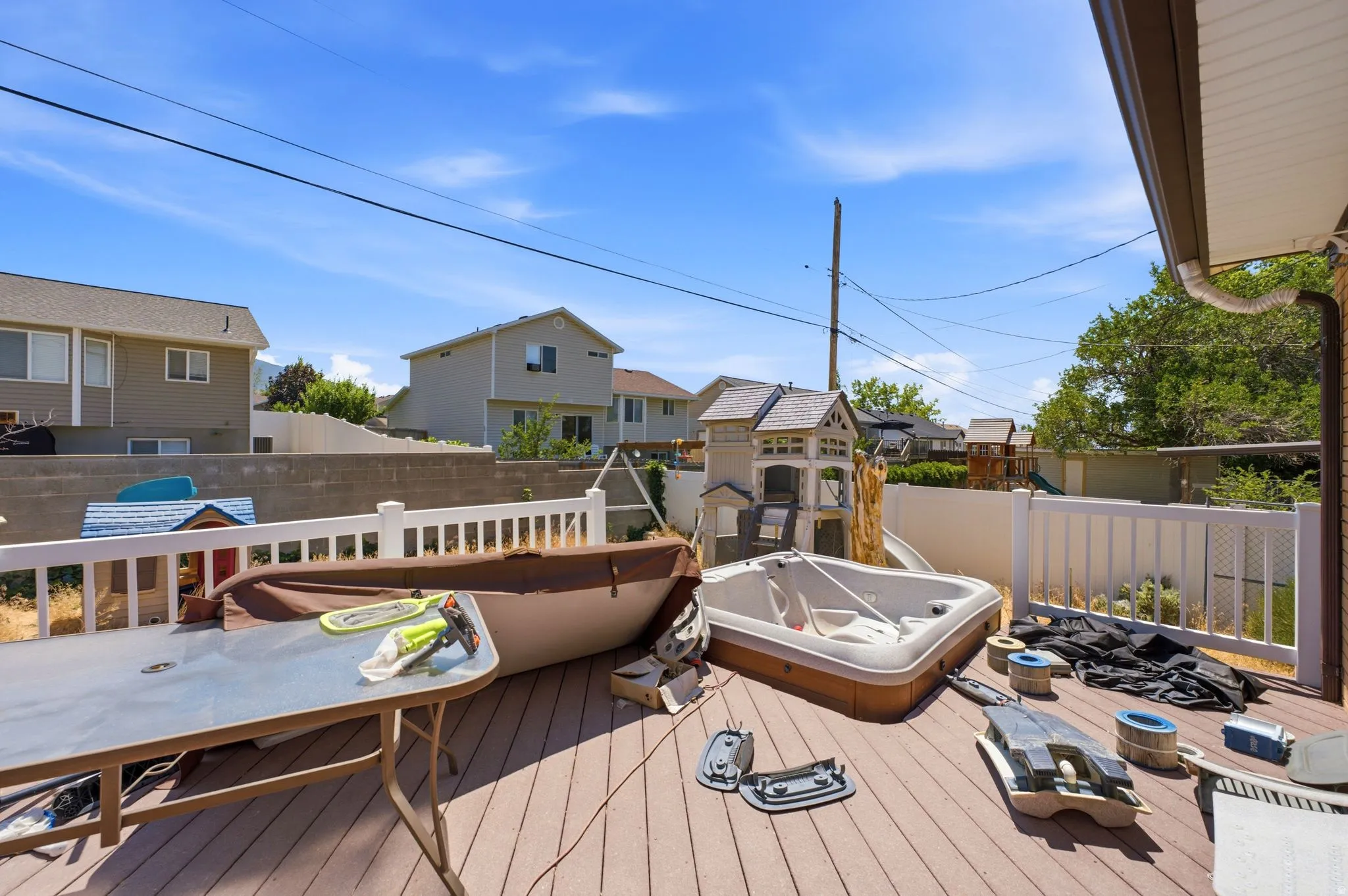Expansive composite deck featuring white railing and a built-in spa