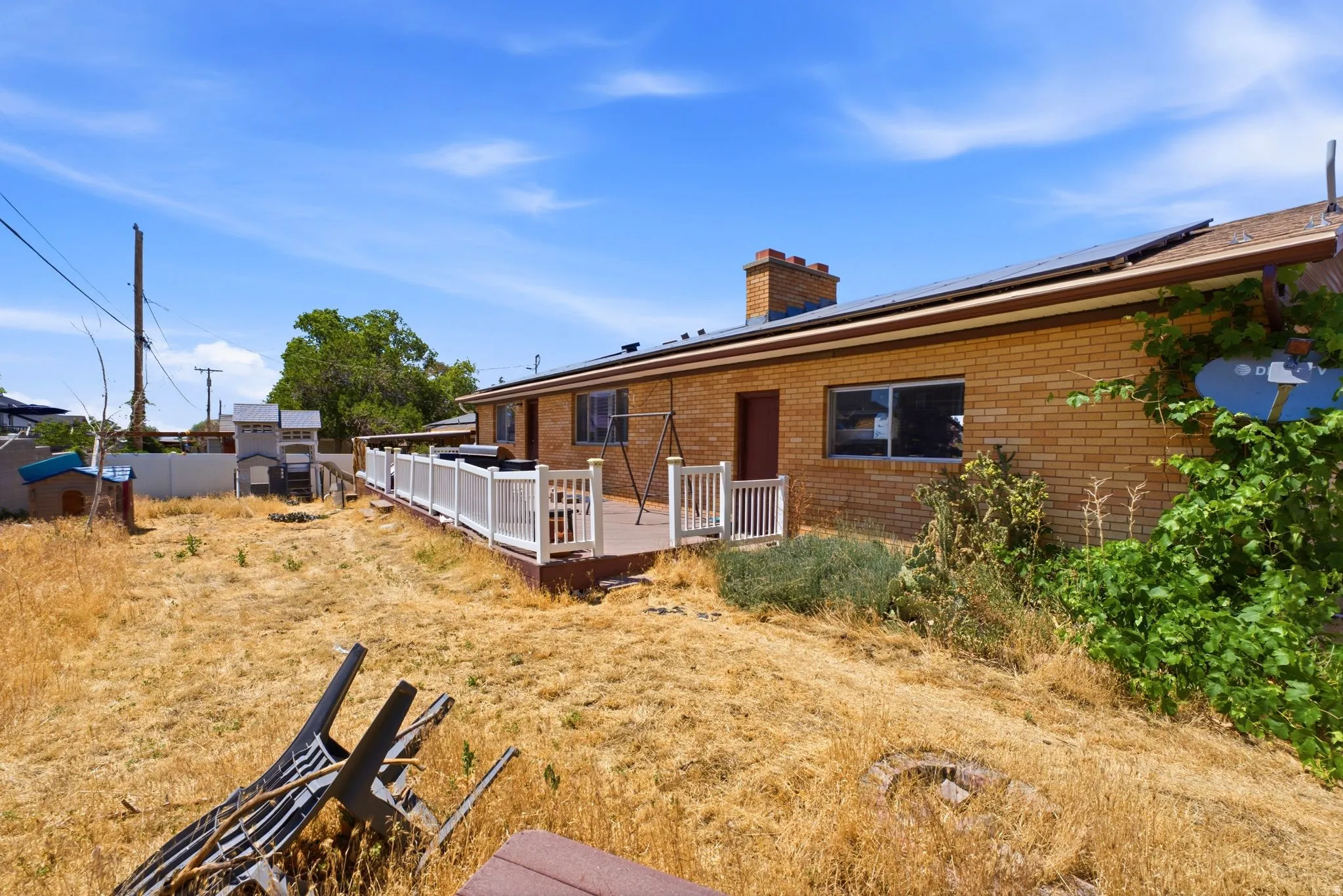Rear exterior featuring a brick facade, chimney, and solar panels