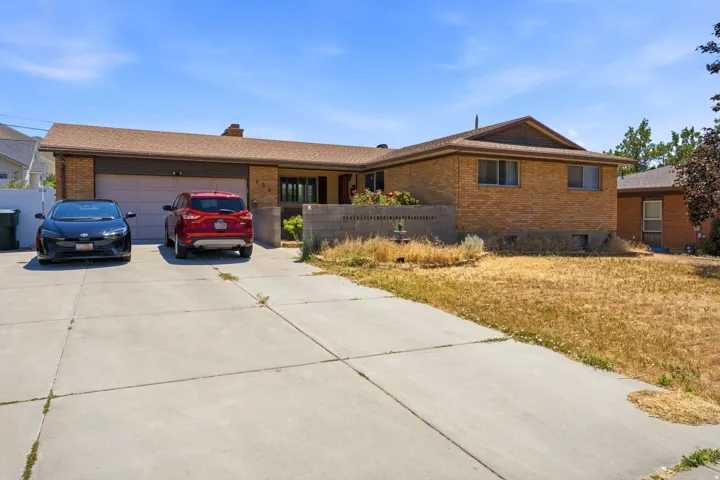 Brick facade exterior with a two-car garage, concrete driveway, and covered entry