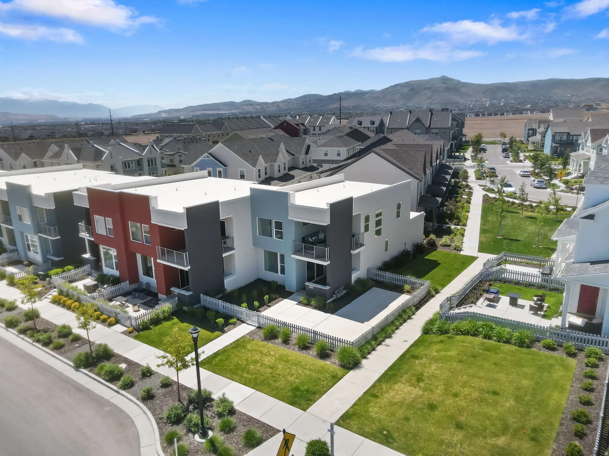 Modern multi-story exteriors with varied facades, individual balconies, and fenced patios