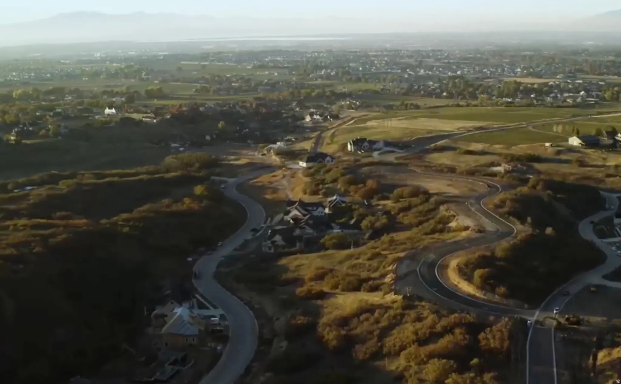 Winding roads traverse a developing residential area with established homes and new construction