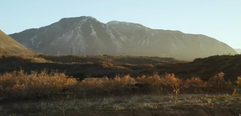 Mountain landscape with distant snow-capped peaks and rolling hills