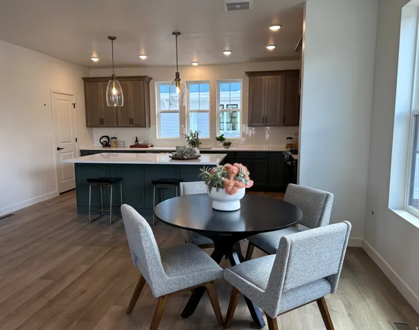 Open-concept kitchen and dining area featuring wood-finish flooring, recessed lighting, and pendant lighting fixtures