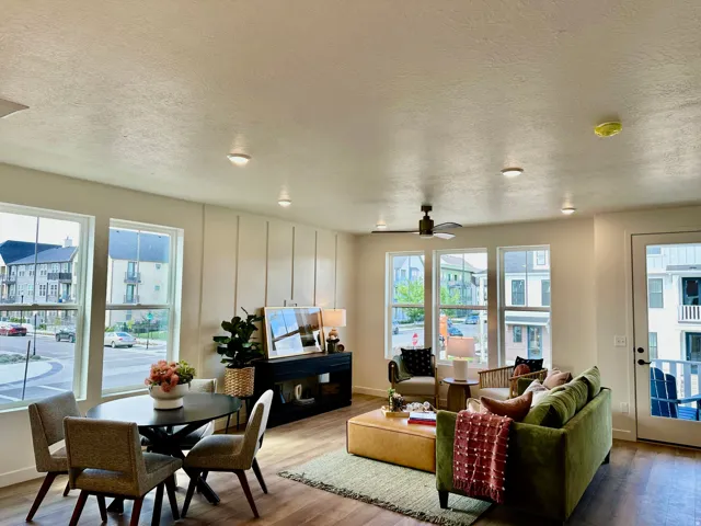 Open-concept living area with wood-finish flooring, recessed lighting, and a ceiling fan