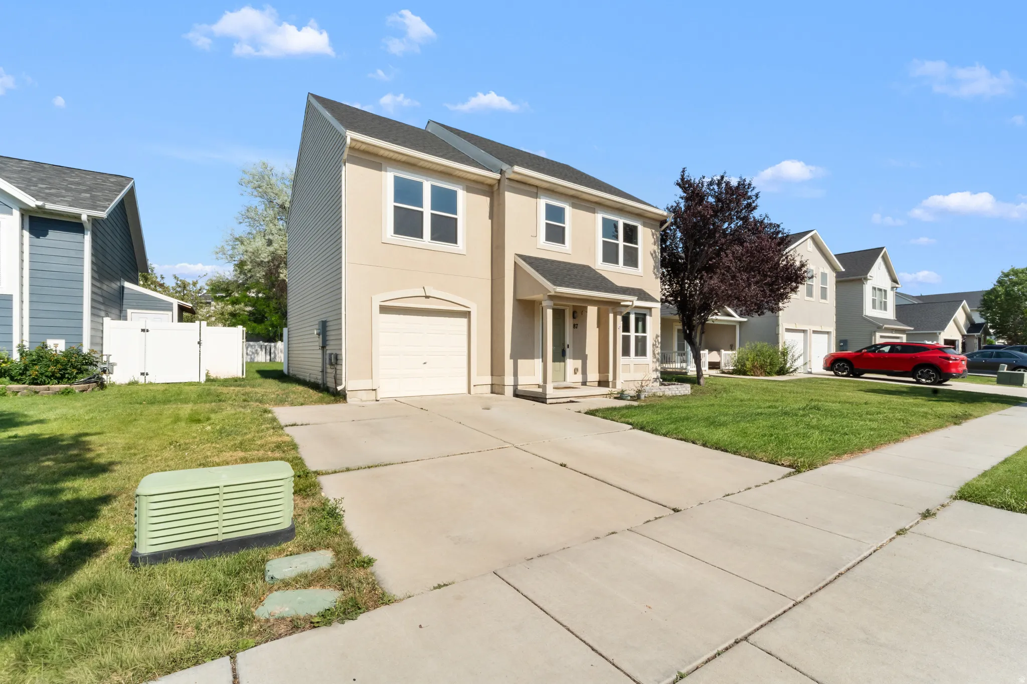 Stucco exterior with a two-story design, featuring a covered front entry and a single-car garage