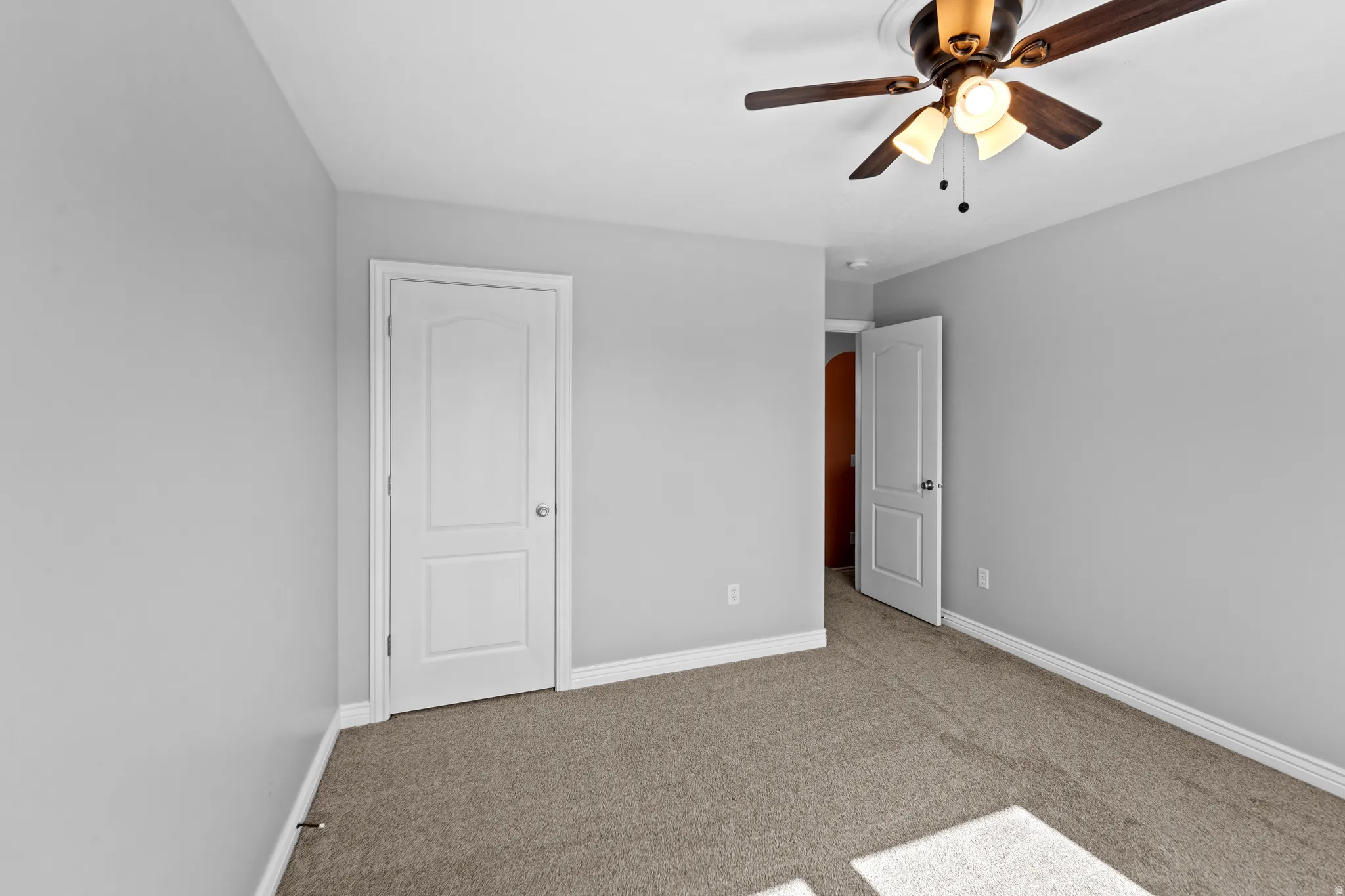 Carpeted room with light gray walls, white baseboards, and a ceiling fan with integrated lighting