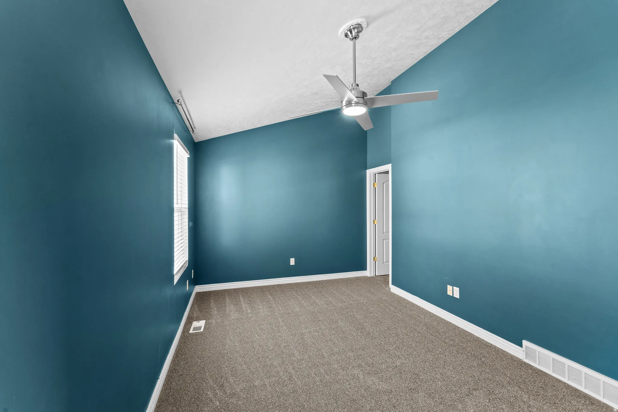 Room featuring a vaulted ceiling with a modern ceiling fan, carpeted flooring, a window with blinds, and white trim molding
