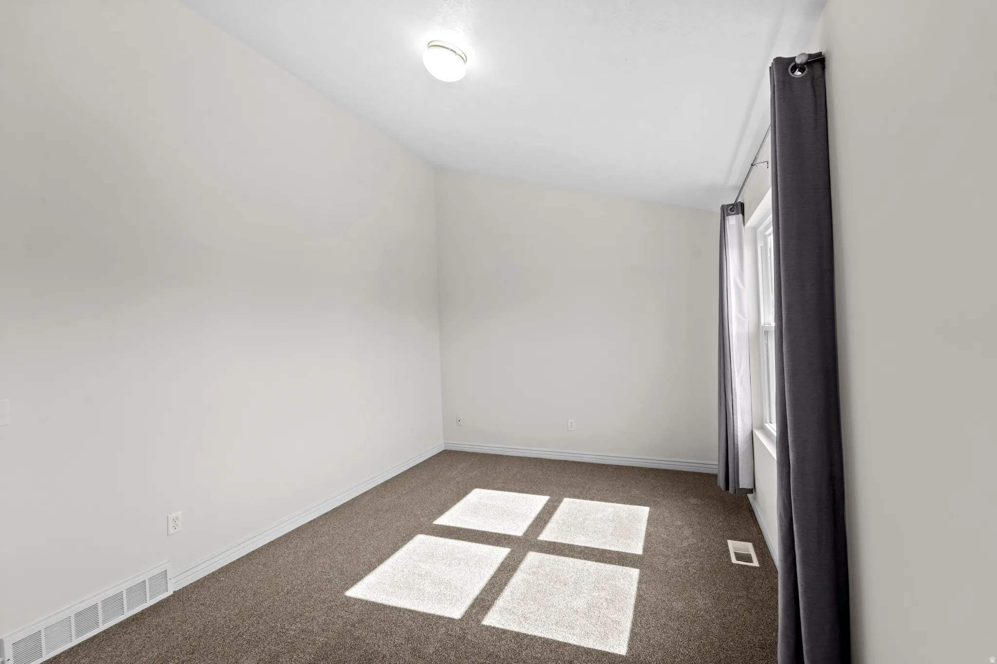 Room featuring light-toned walls and neutral-toned carpeting