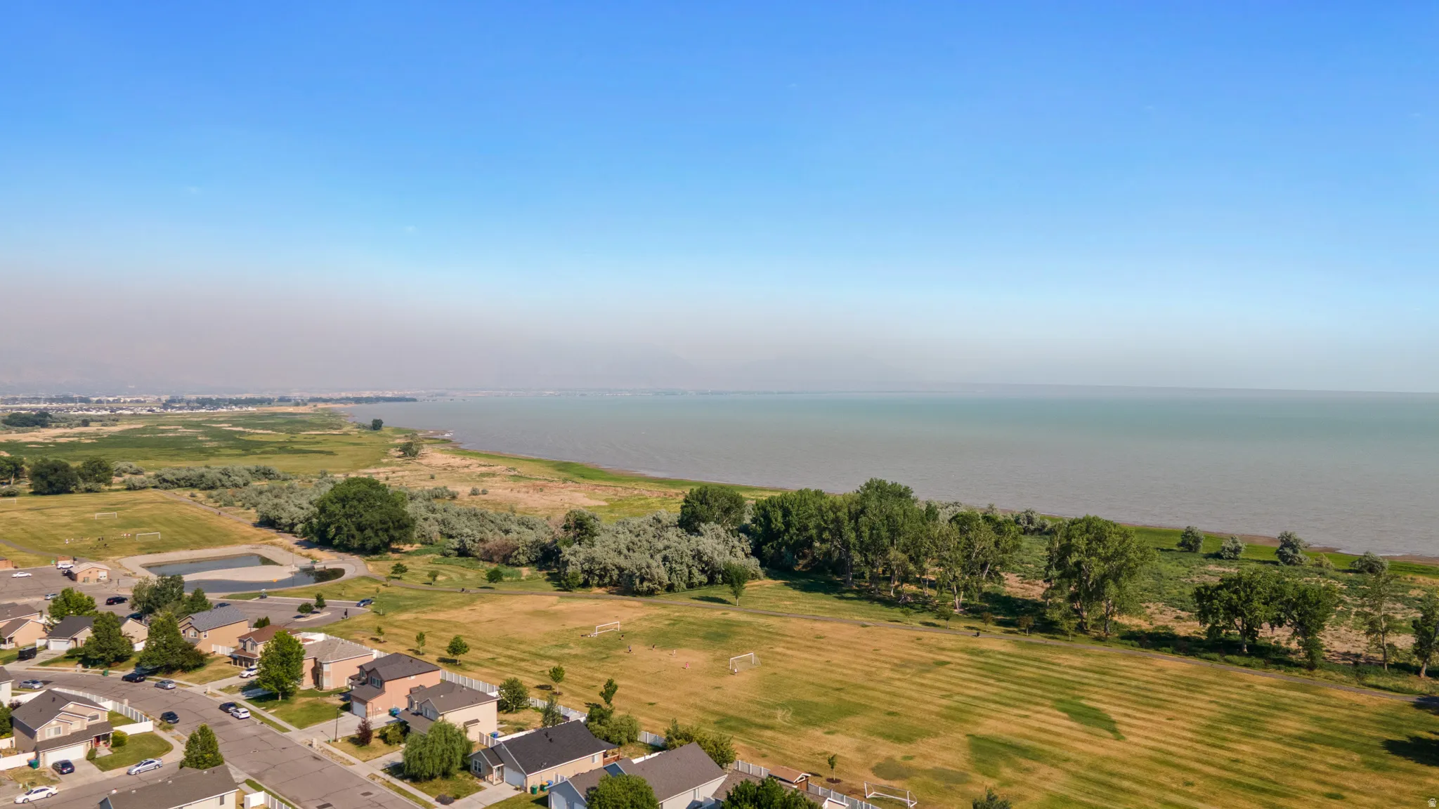 Expansive aerial perspective showcasing residential properties bordering a large body of water