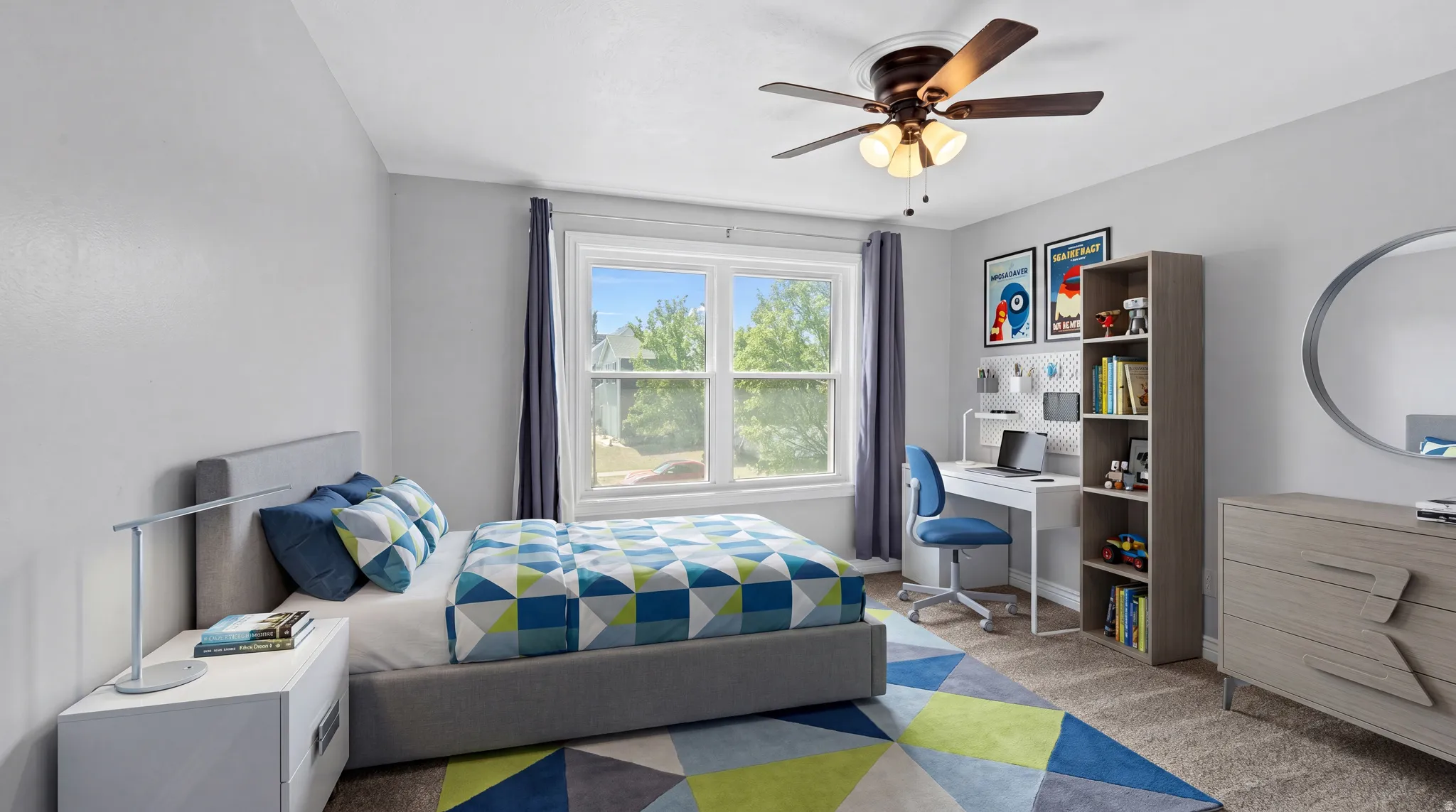 Bright interior room featuring light gray walls, a window with exterior views, and a ceiling fan with integrated lighting