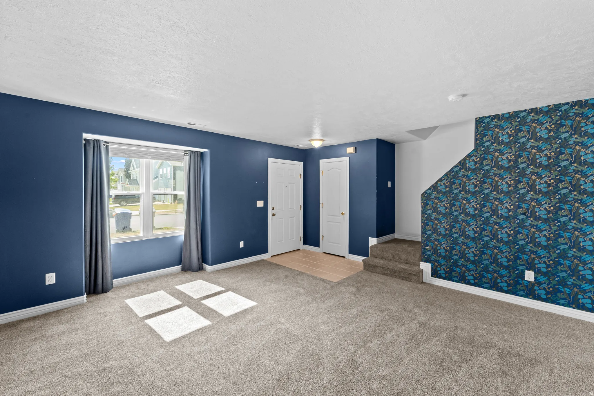 Living area featuring blue accent walls and a patterned accent wall