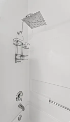 White bath and shower combination featuring a square rainfall showerhead