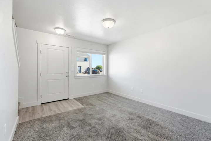 Entryway featuring a white paneled door, wood-finish flooring, and a large window