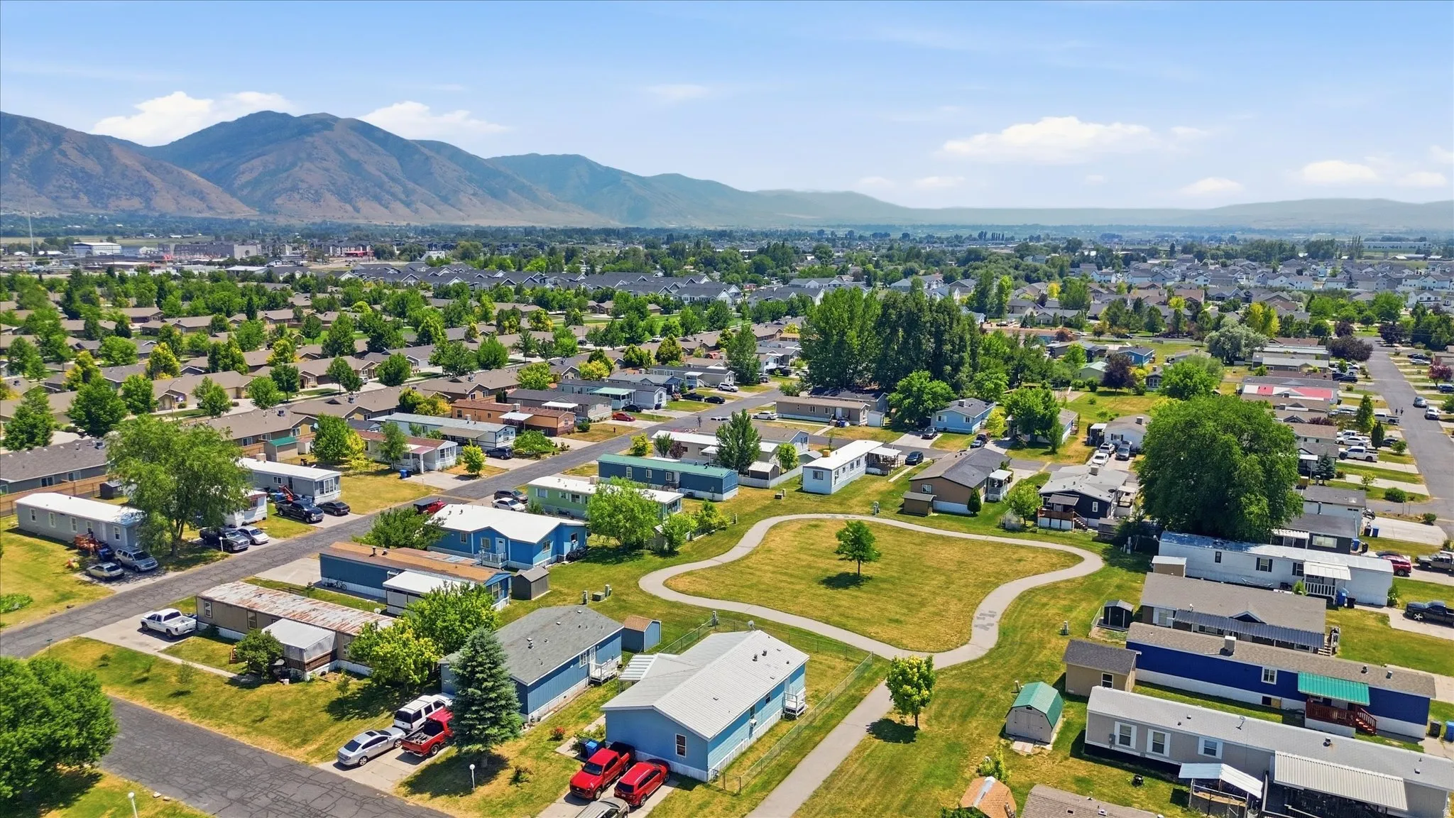Expansive aerial perspective showcasing a neighborhood with varied residential structures and abundant mature trees