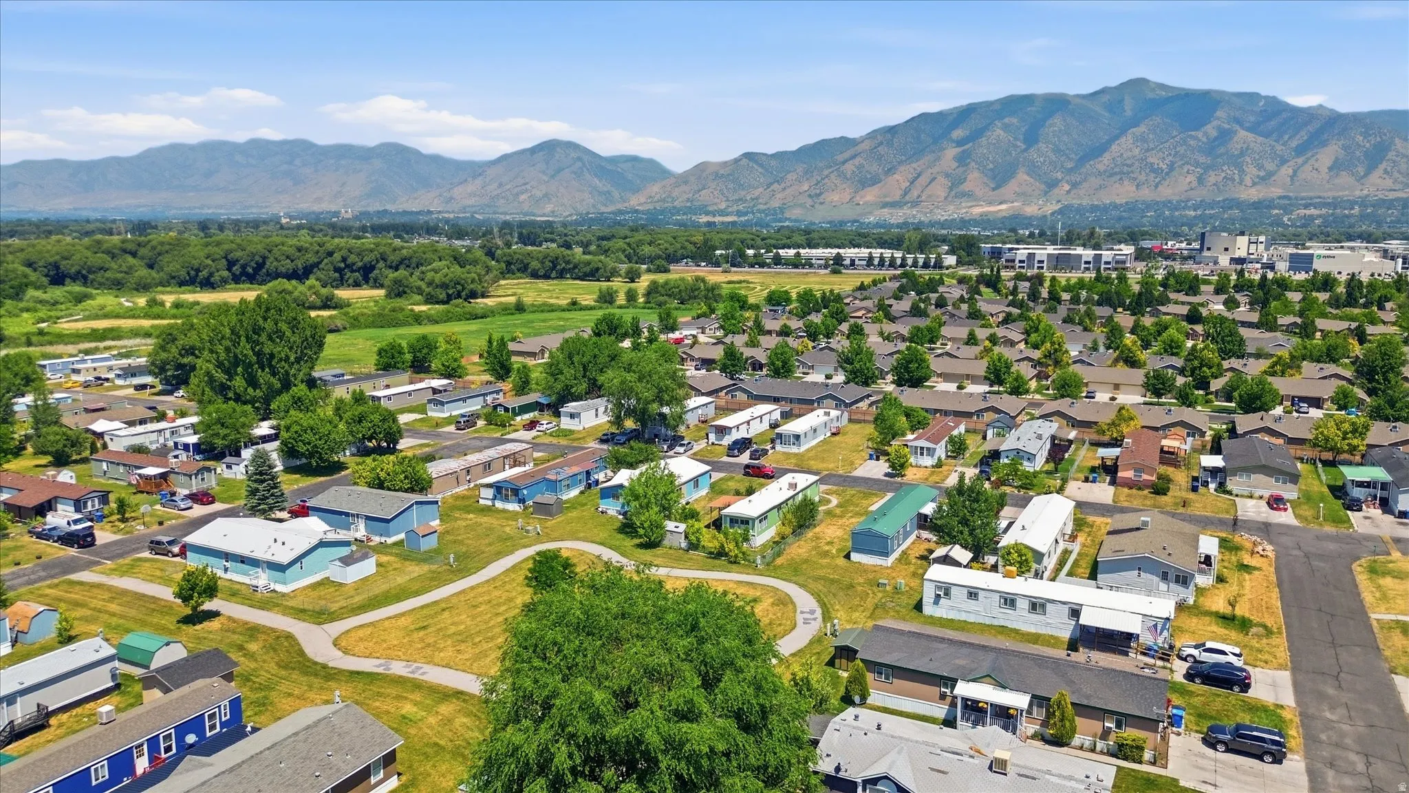 Aerial perspective showcasing a residential community with abundant green spaces and mature trees