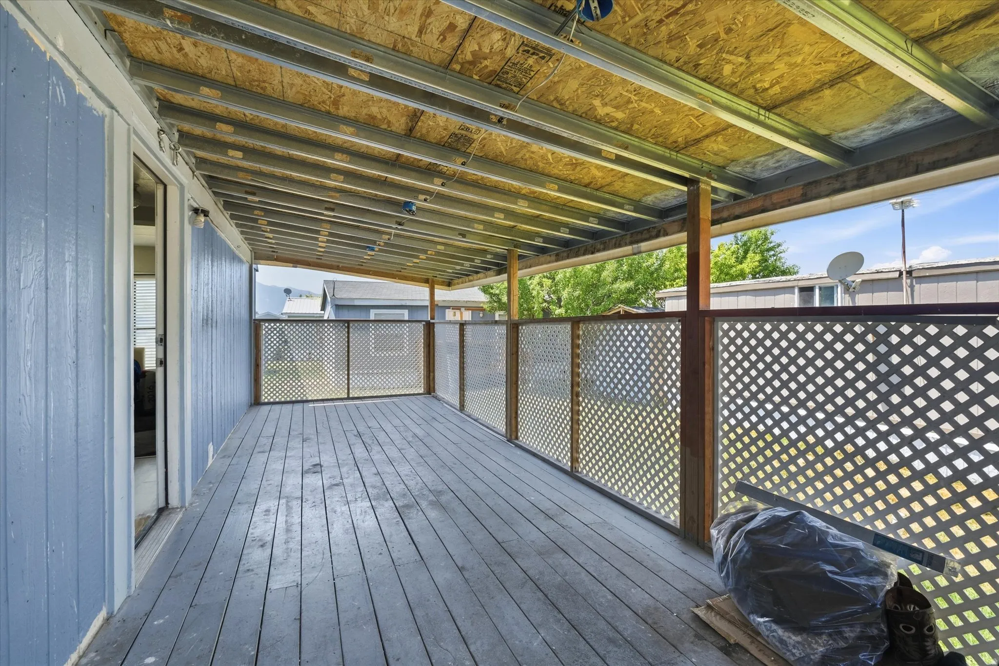 Covered outdoor deck with light blue wood-finish siding