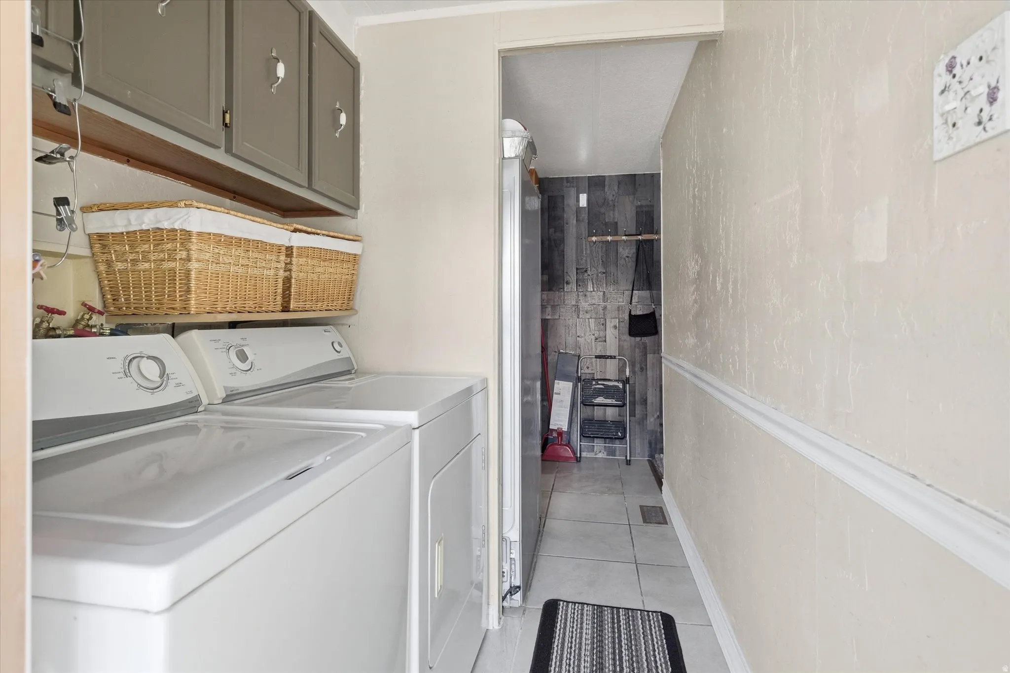 Dedicated laundry area featuring upper cabinetry and an open shelf
