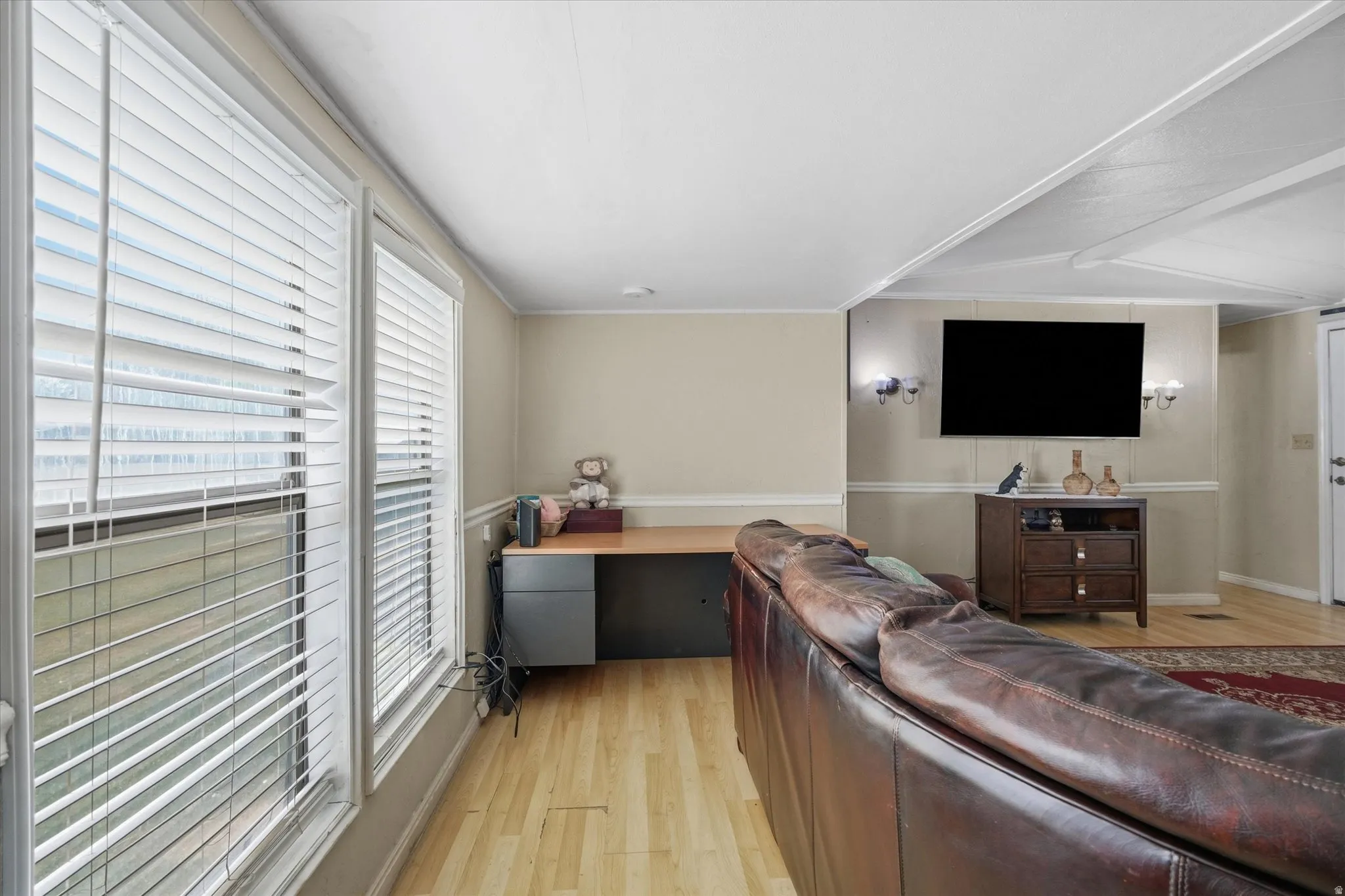Light wood-finish flooring complements the neutral wall color