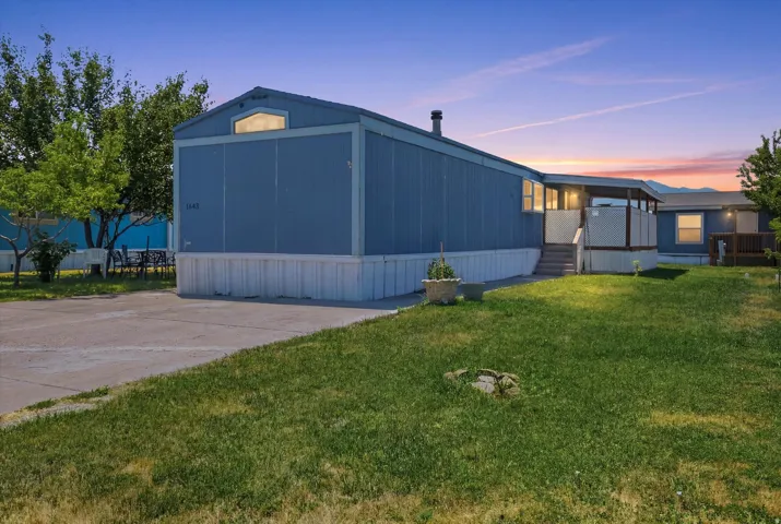 Property exterior featuring a blue siding finish, a covered porch entrance, and a well-maintained lawn