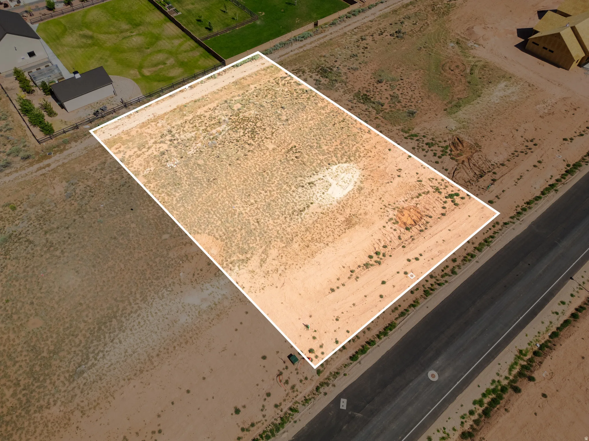 Expansive desert lot featuring a perimeter outline, level topography, and direct road frontage