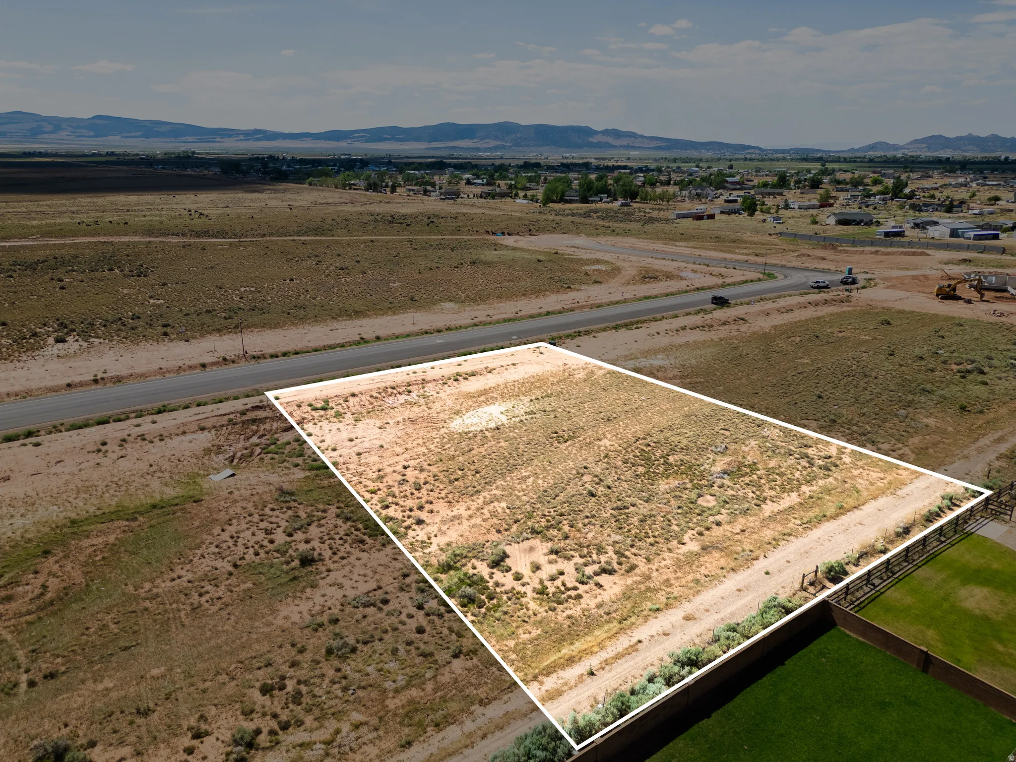 Expansive parcel featuring a defined boundary, direct road frontage, and a partially fenced perimeter