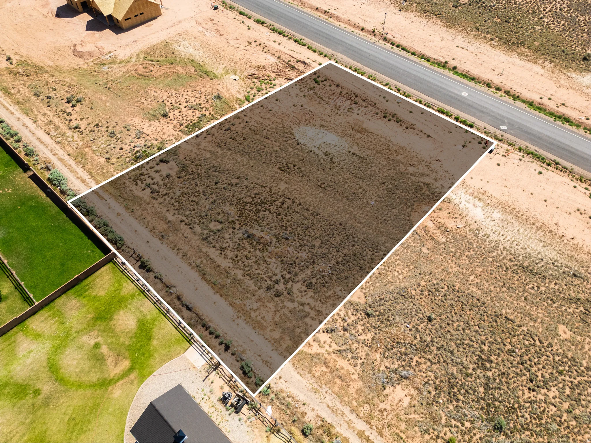 Expansive undeveloped lot featuring natural desert landscaping and direct road frontage