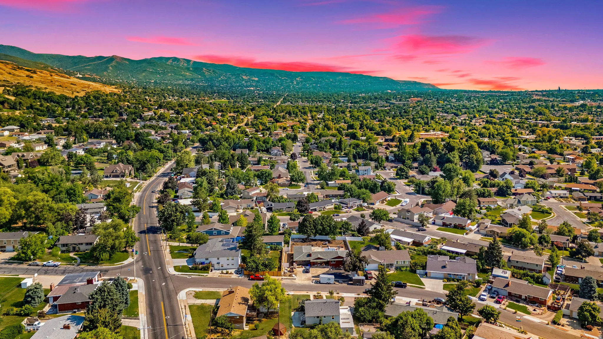 Sprawling residential area featuring numerous single-family homes with mature trees and paved roads